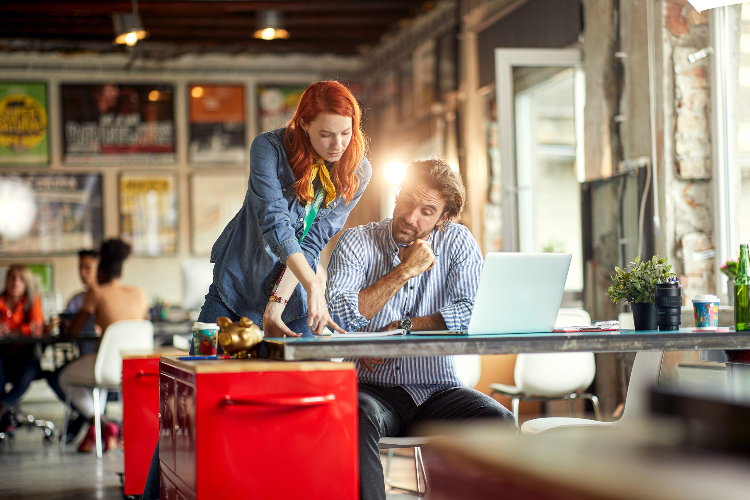 Young colleagues are analyzing documents while working in the of